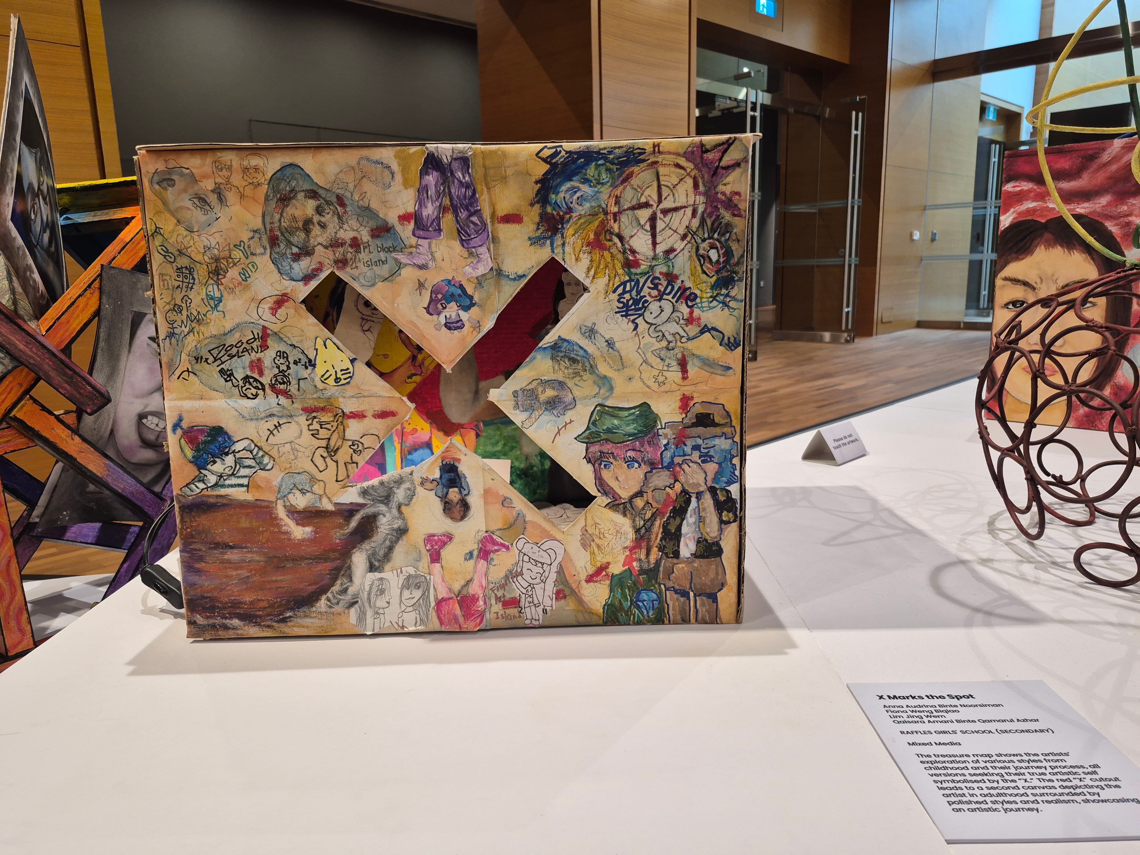 A closeup of an artwork with a 'X'.